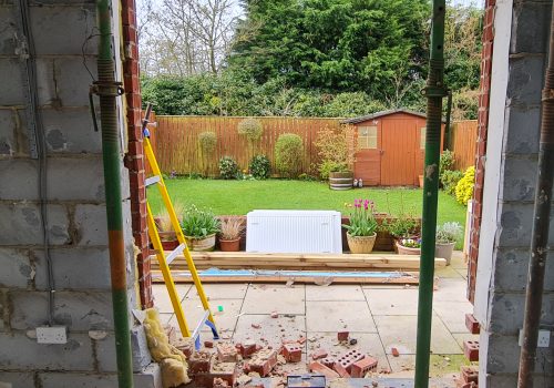 An opening in block work supported by two acro props.