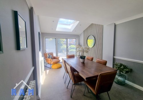 An internal shot of a new extension. Furniture in the foreground with natural light flowing into the room.