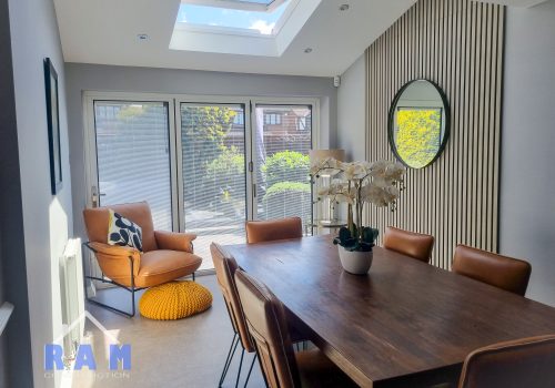 An internal shot of a new extension. Furniture in the foreground with natural light flowing into the room.